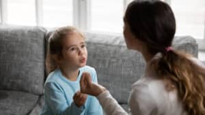 Small girl child pronounce sounds with speech therapist