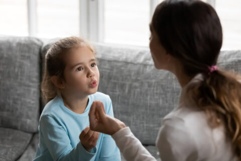 Small girl child pronounce sounds with speech therapist