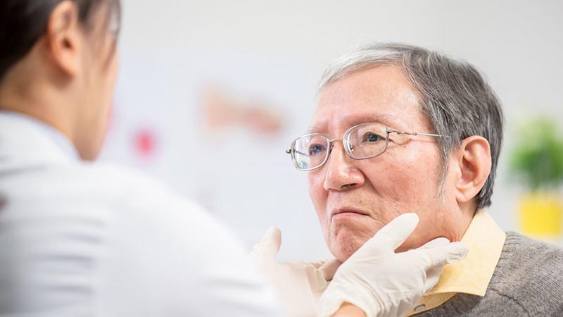 Lady taking care of old Chinese man and lady wearing hand gloves