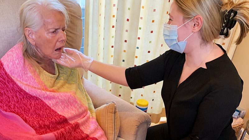 Woman taking care of senior woman and senior lady sitting on the chair