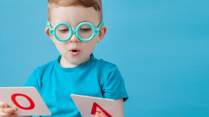 Kids wearing blue t-shirt and playing with letters 