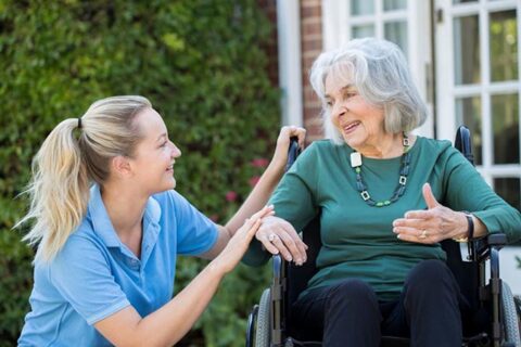 Young woman spending her time with old woman outside the home