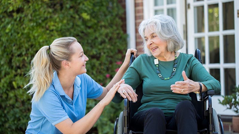 Young woman spending her time with old woman outside the home