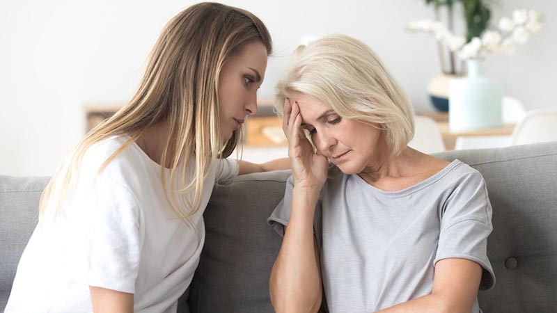 Tense Mother and daughter sitting on the sofa at the home