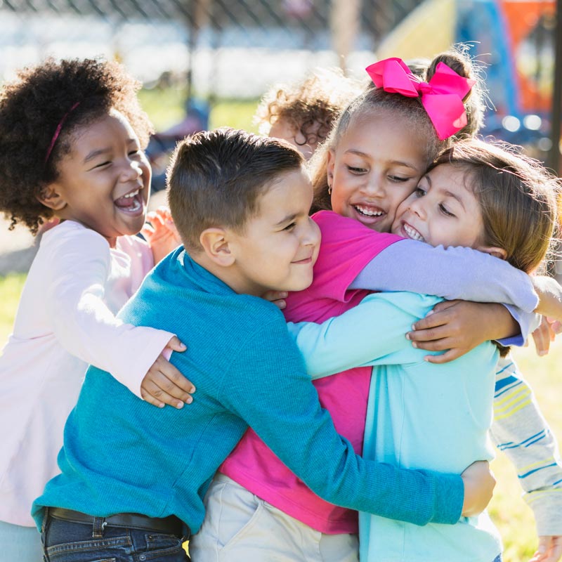 children hugging on playground