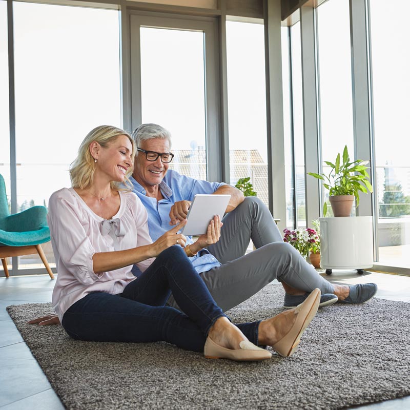 couple sitting on the floor looking at iPad
