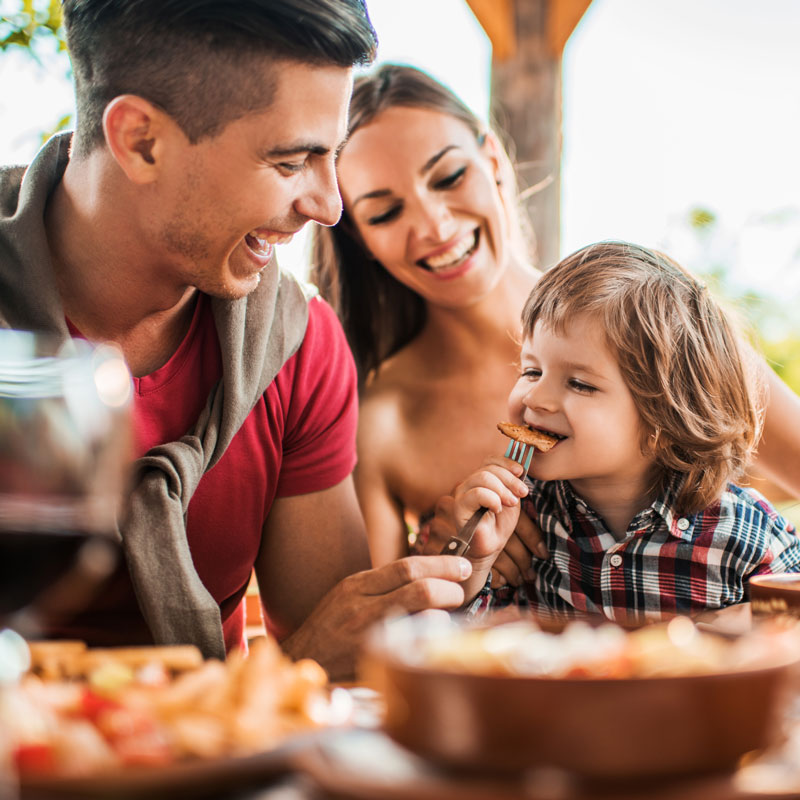 young parents eating with little boy