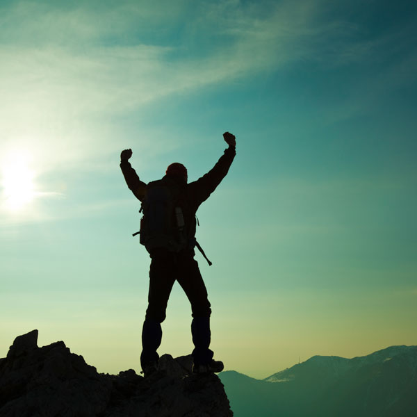 man excited on top of mountain