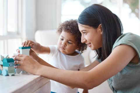 Shot of a young mother and daughter playing with a toy at home