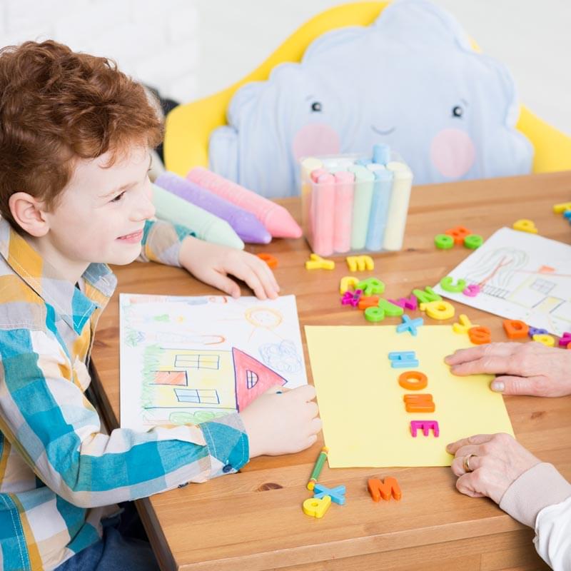 little boy learning to spell "Home"